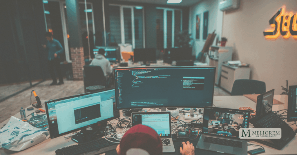 A person working in a room with lots of screen. could be a leader.
